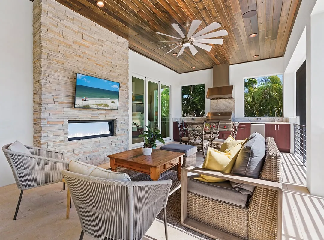 Southern Pine ceiling above an outdoor lounge with a stone fireplace and kitchen