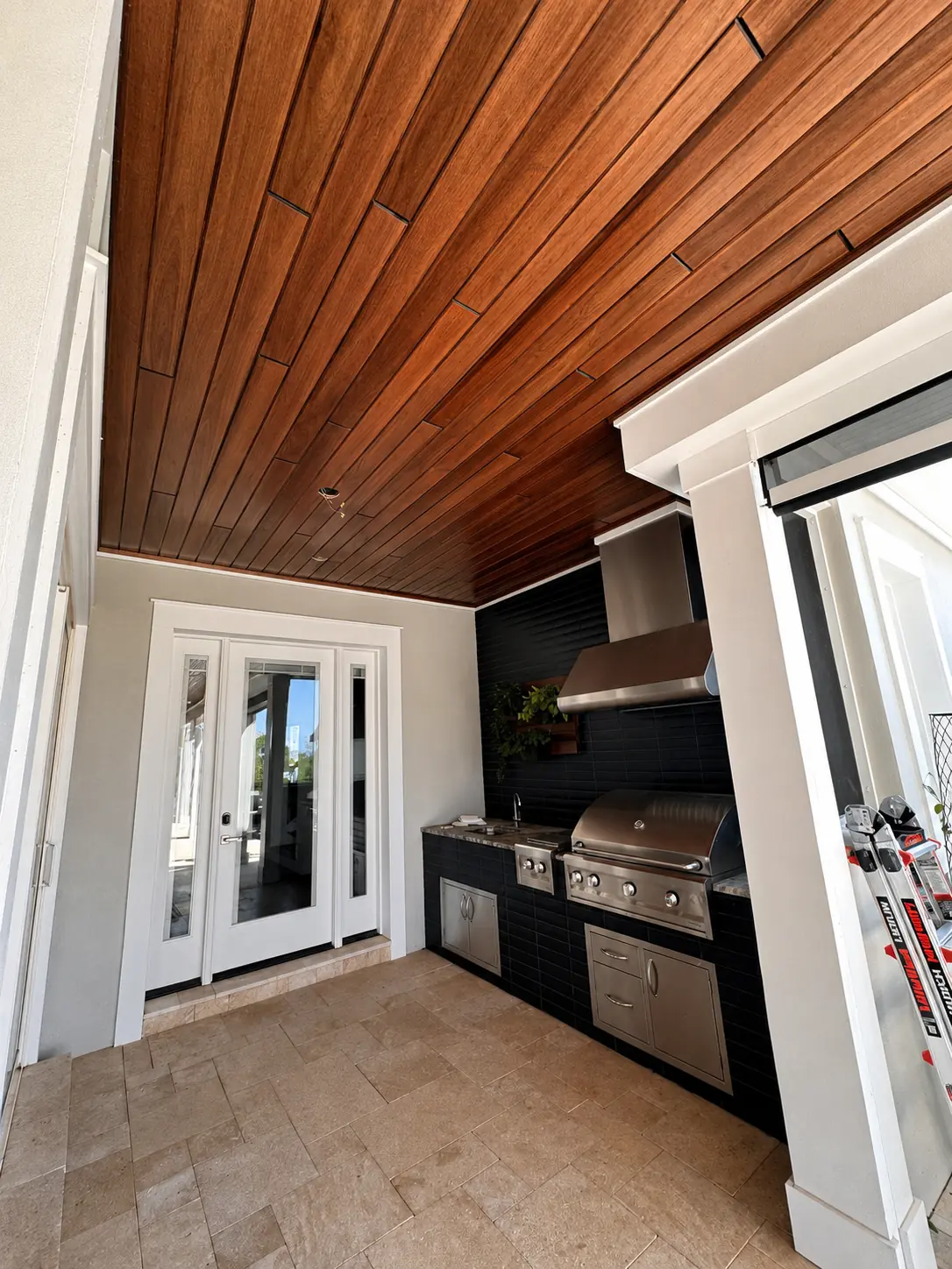 Red Grandis Auburn prefinished wood ceiling on a covered porch by Novus Renovations